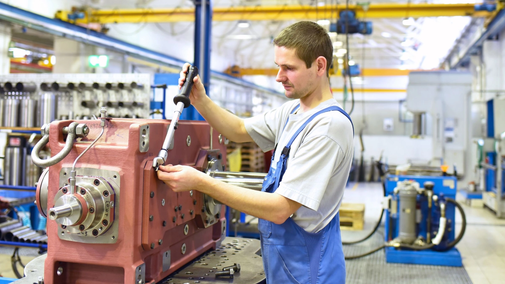 Beschäftigter arbeitet an einem Getriebe in einer Fabrik